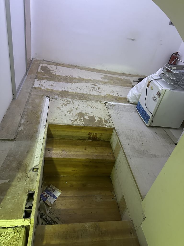 Bontási munkálatok közben kialakított új lépcsőlejárat, padlóáttörés és falvágás üzleti belső térben.