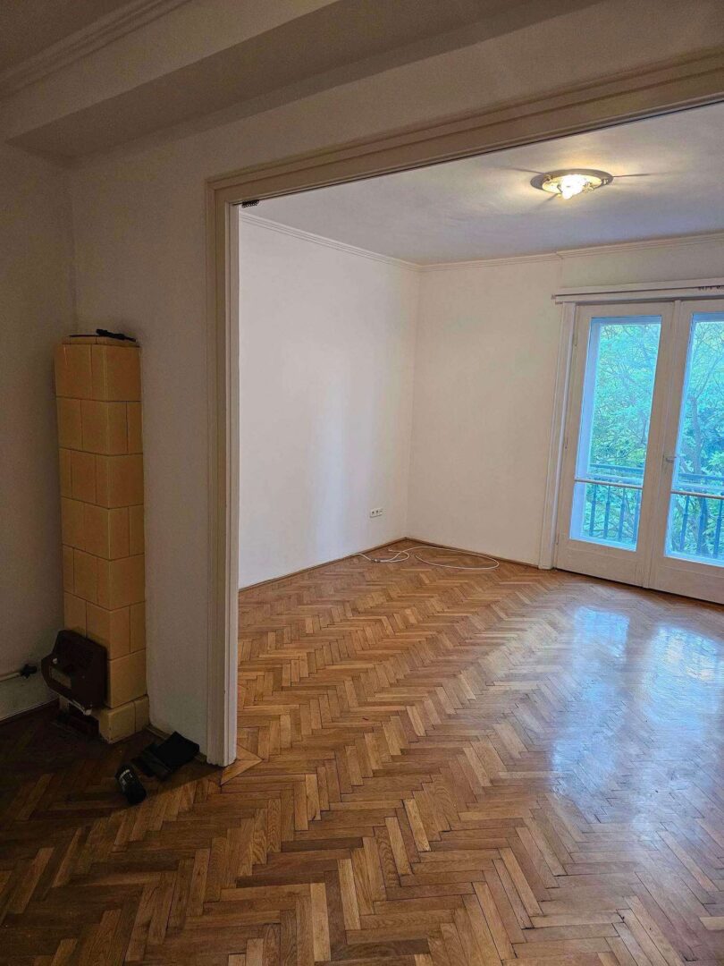 Térelválasztó fal bontása után kialakított egybenyitott nappali Budapest belvárosában, parkettás burkolattal