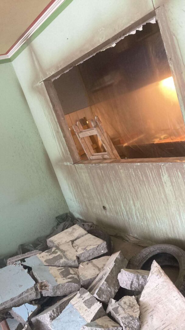 Betonfalba vágott új nyílás bontási törmelékkel, ProCut precíziós kivitelezés belső munkaterületen, ipari fényviszonyok között.