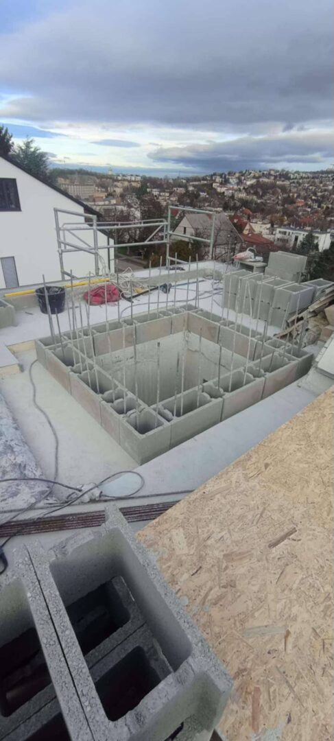 Zsaluzott, vasalt aknaszerkezet betonozás előkészítése során egy épület tetőszintjén, városi kilátással, ProCut kivitelezésben.